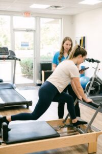 Patient performing Pilates-based movement assessment at a sports physical therapy clinic in Farmingdale for functional evaluation