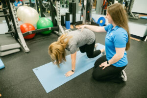 woman with osteoporosis doing bear crawl pose