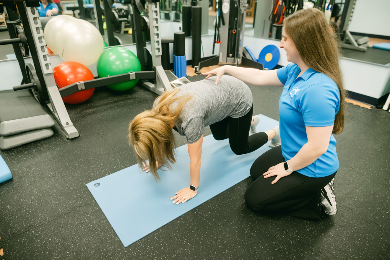 woman with osteoporosis doing bear crawl pose
